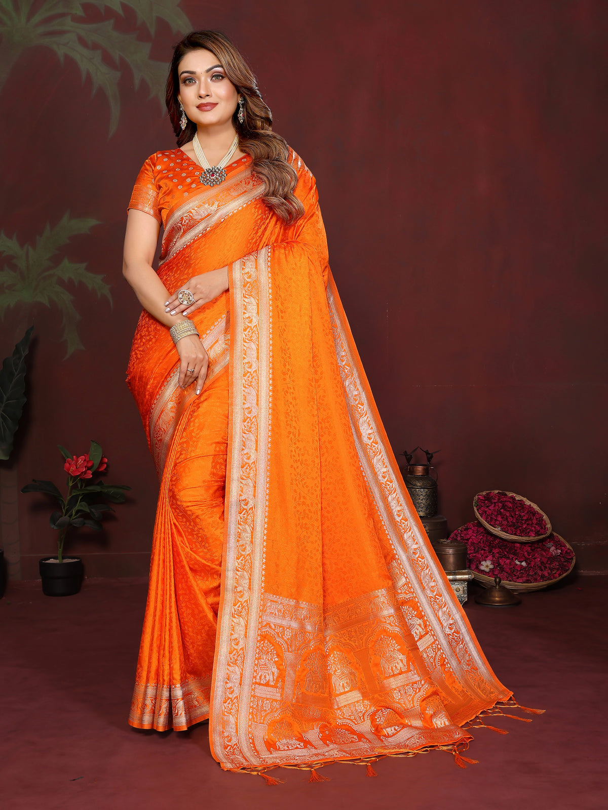 Woman wearing an orange saree with a brown background