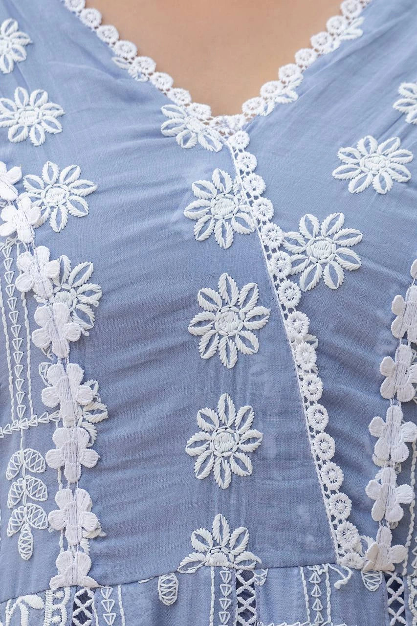 Close-up of a blue fabric with white floral embroidery