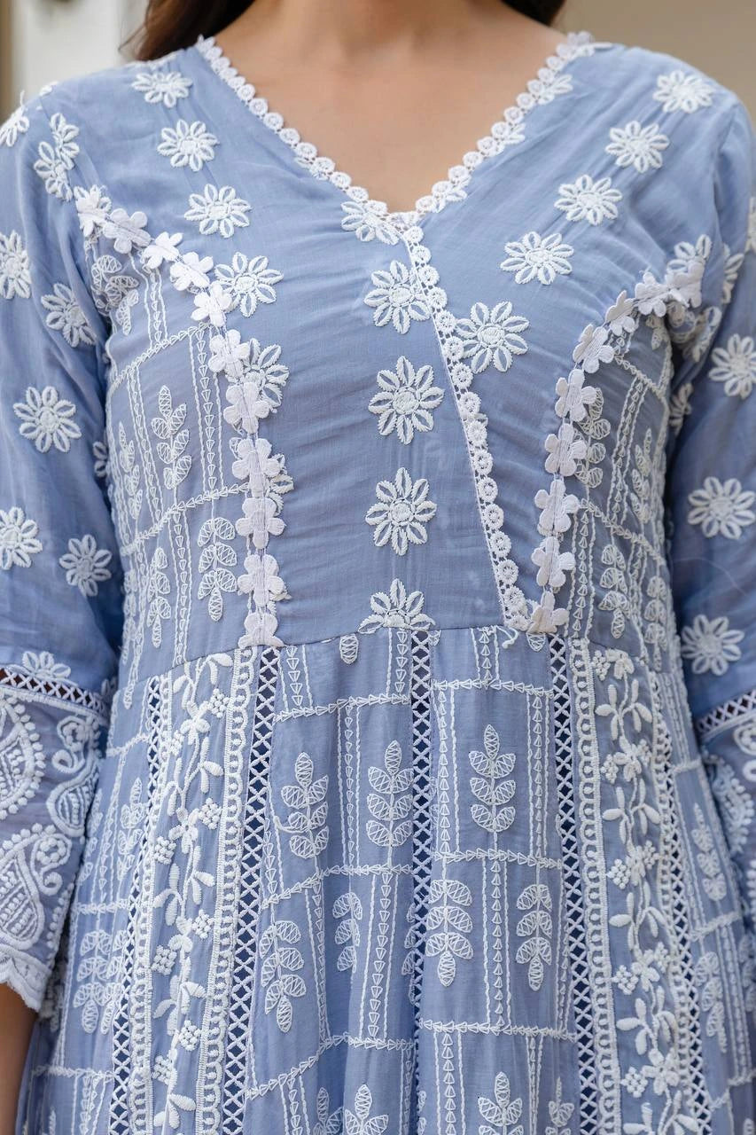 Close-up of a blue embroidered dress with white floral patterns