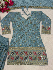 Decorative blue garment with intricate patterns on a light gray background