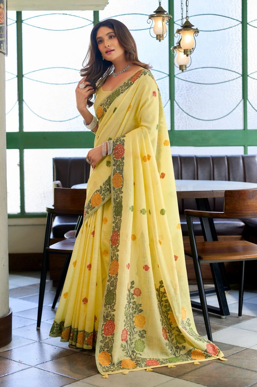 Woman in a yellow saree with floral patterns in an indoor setting