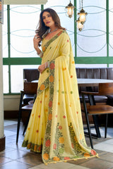 Woman in a yellow saree with floral patterns in an indoor setting