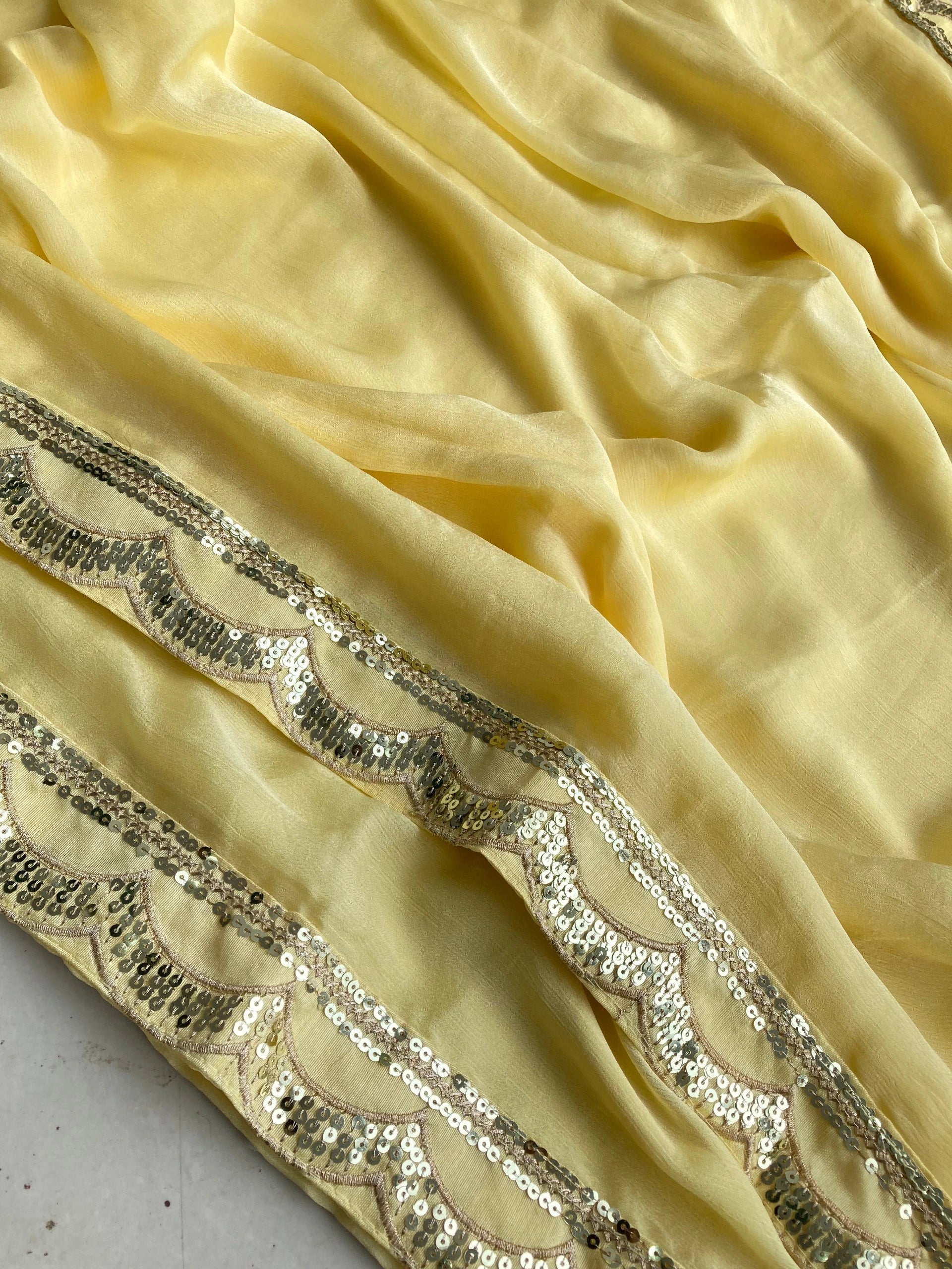 Close-up of yellow fabric with decorative silver sequin border