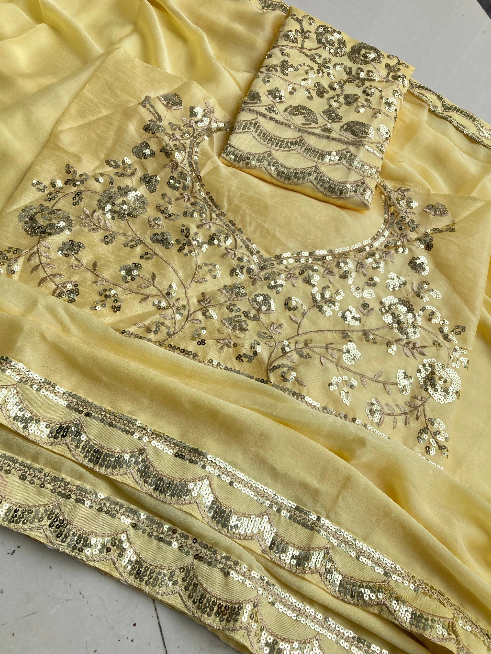 Beige saree with intricate silver embroidery on a white background