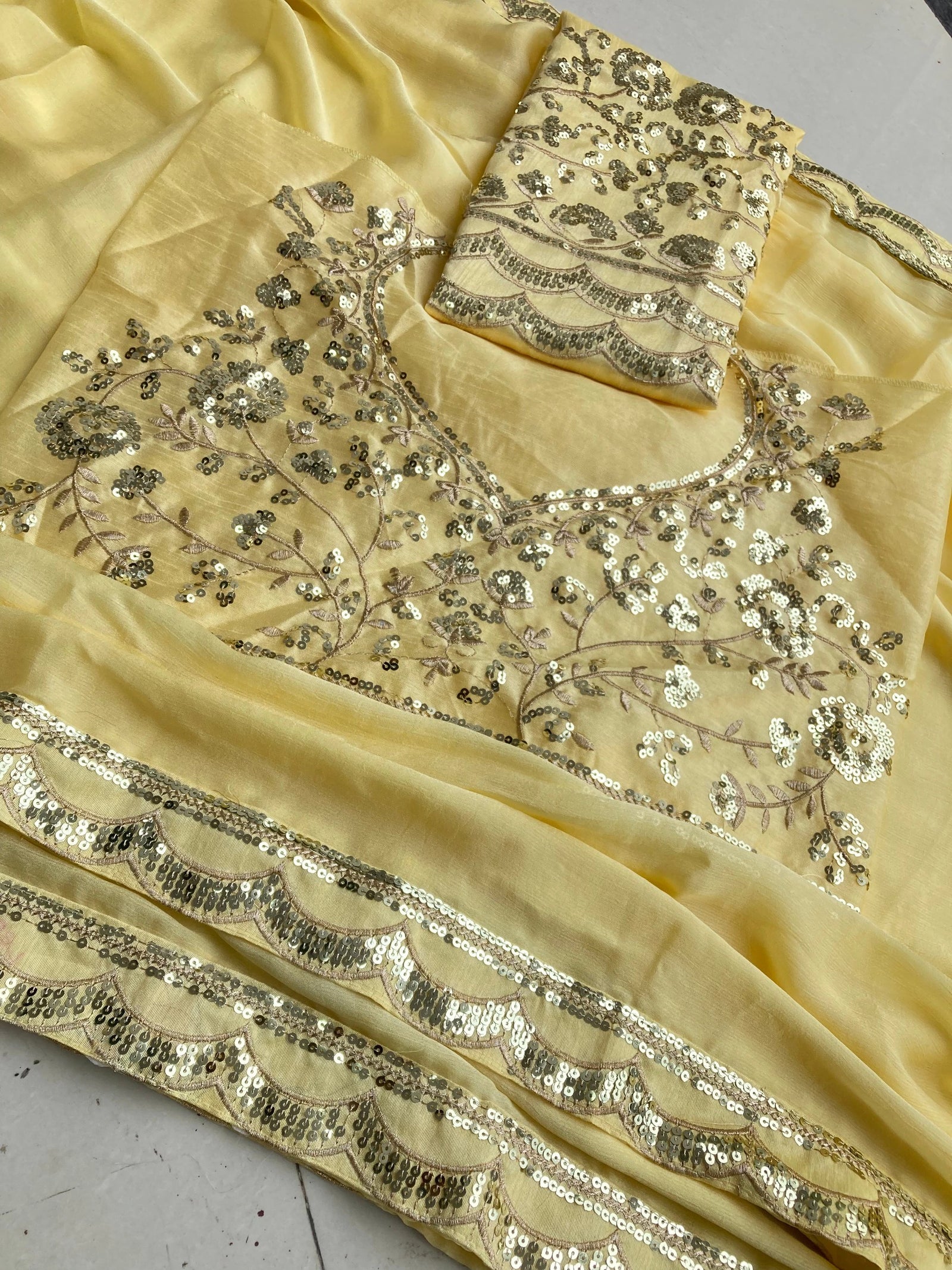 Beige saree with intricate silver embroidery on a white background