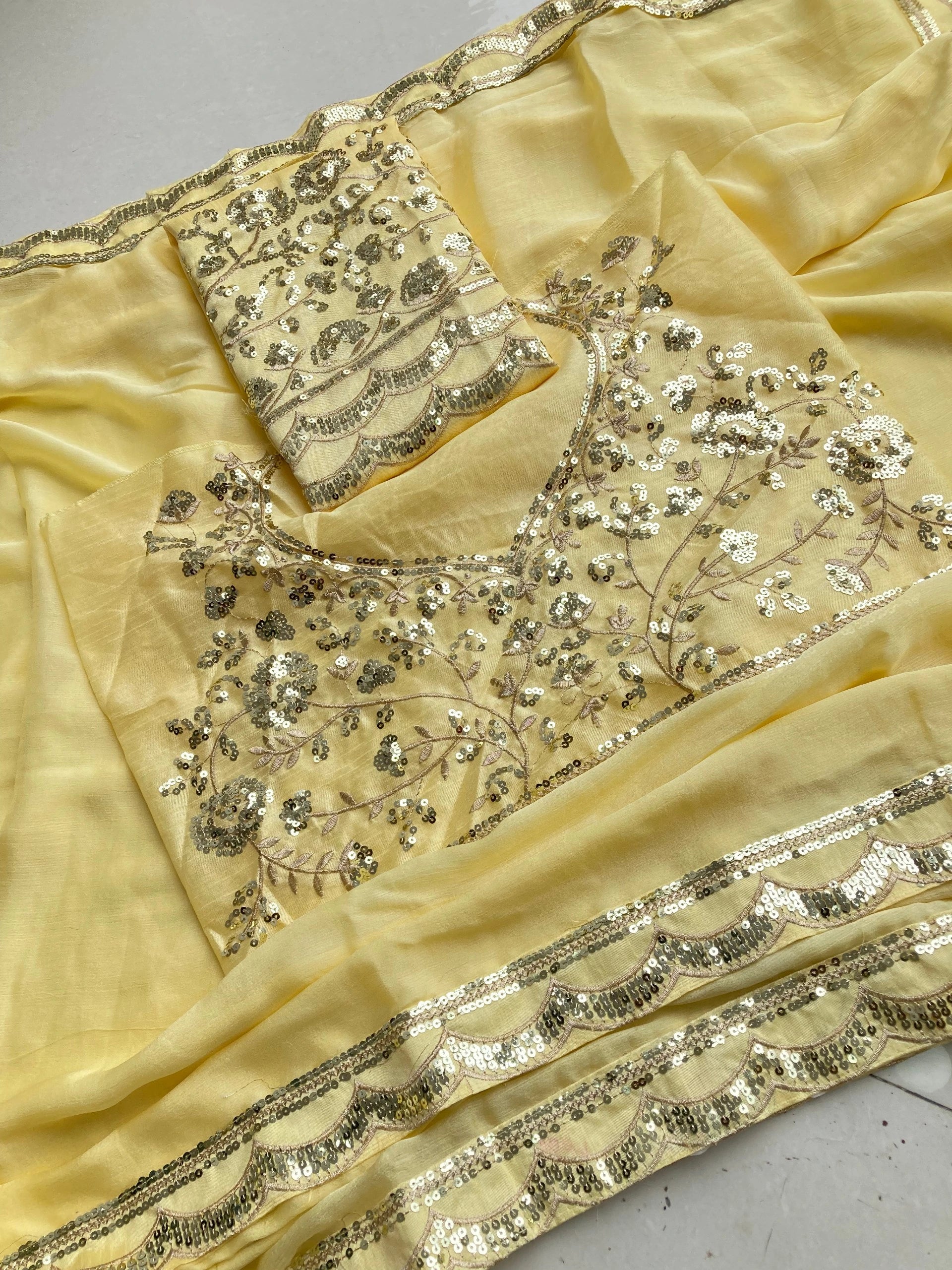 Beige fabric with intricate silver embroidery on a gray surface