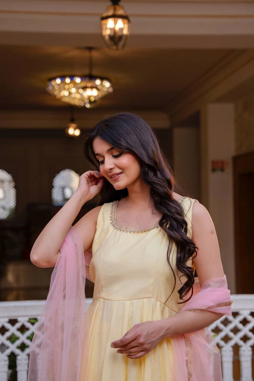 Woman in a yellow dress with pink dupatta indoors