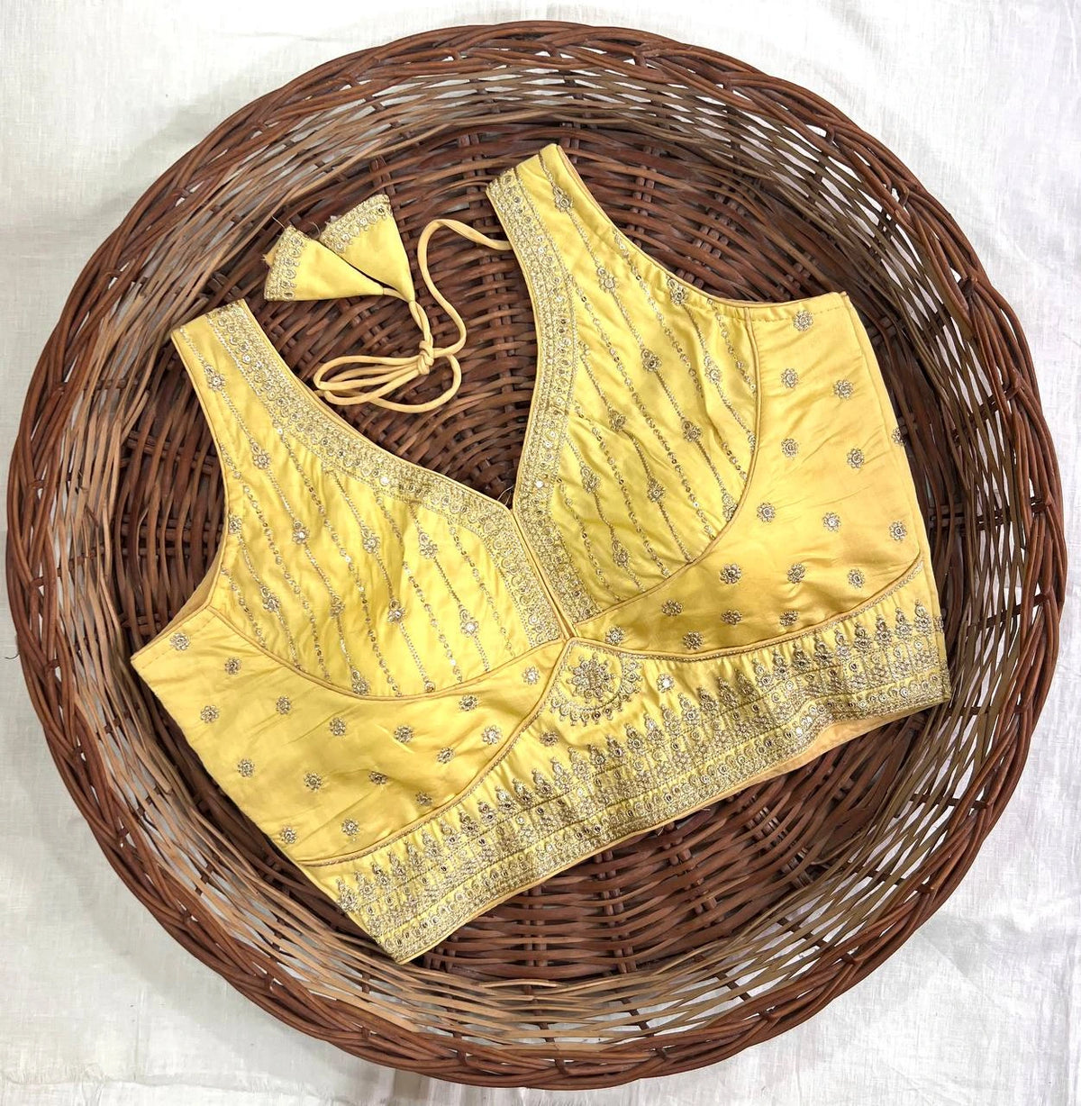 Yellow embroidered blouse on a woven basket