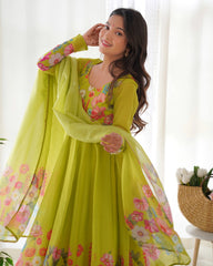 Woman wearing a bright green floral dress with a matching dupatta in a bright room.