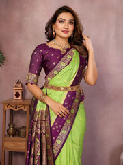 Woman wearing a green and purple saree with jewelry against a neutral background