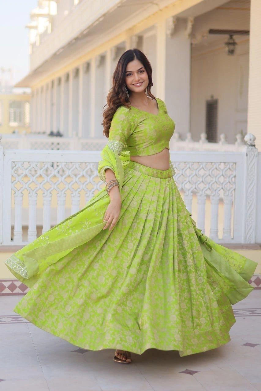 Woman in a bright green traditional outfit standing on a balcony.
