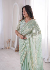 Woman wearing a light green saree with a white background