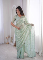 Woman wearing a light green saree with a white background