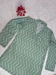 Green patterned shirt on a textured surface with red flowers.