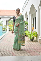 Woman in a light green saree with floral patterns standing on a patio.