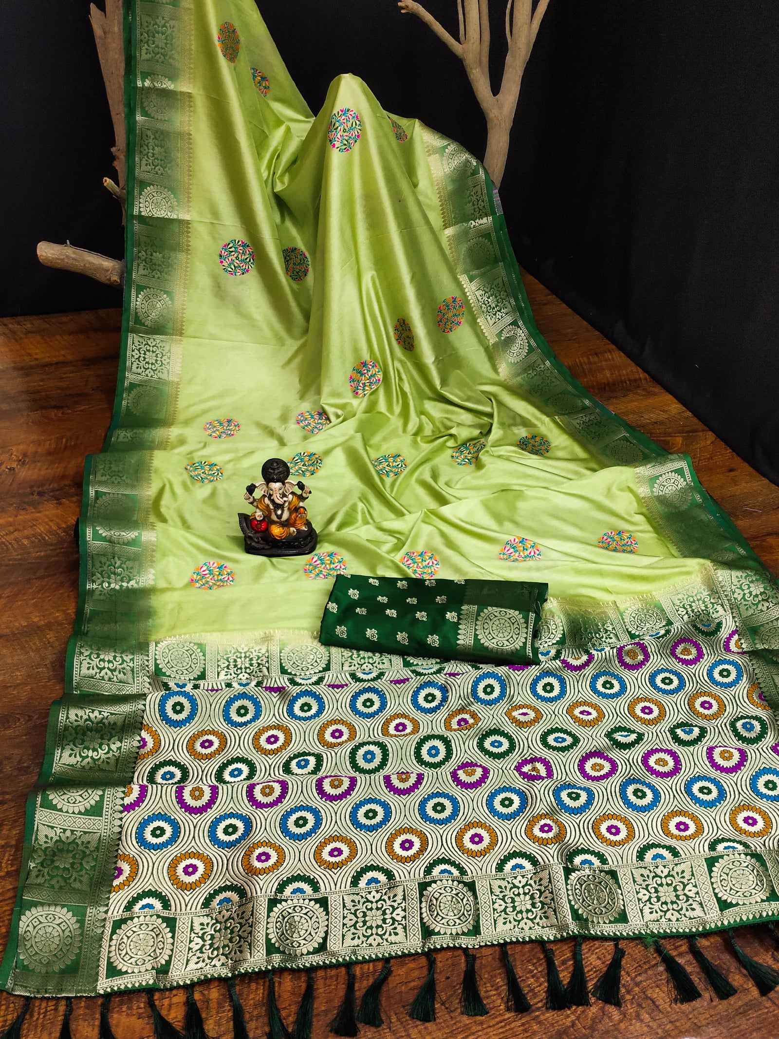 Green saree with intricate patterns on a wooden surface