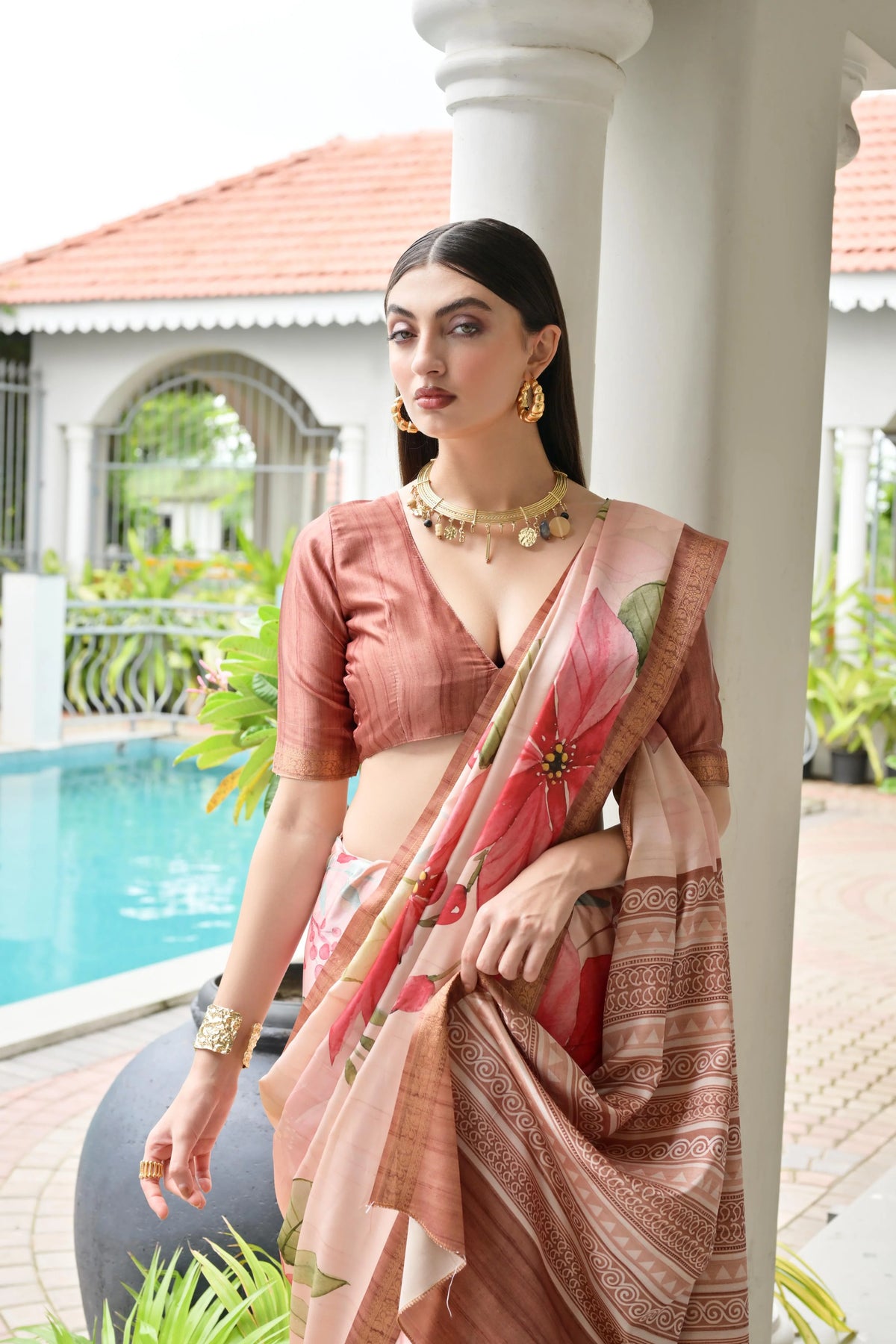 Woman in a traditional saree by a poolside
