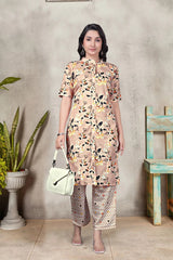 Woman wearing a floral dress with a plant and wooden chair in the background