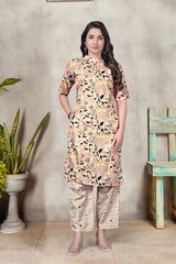 Woman wearing a floral kurta with pants against a gray wall.