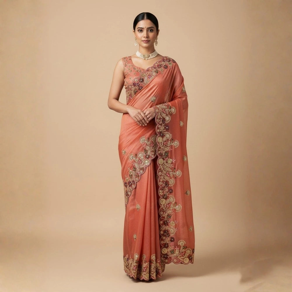 Woman wearing a peach saree with intricate gold embroidery on a beige background