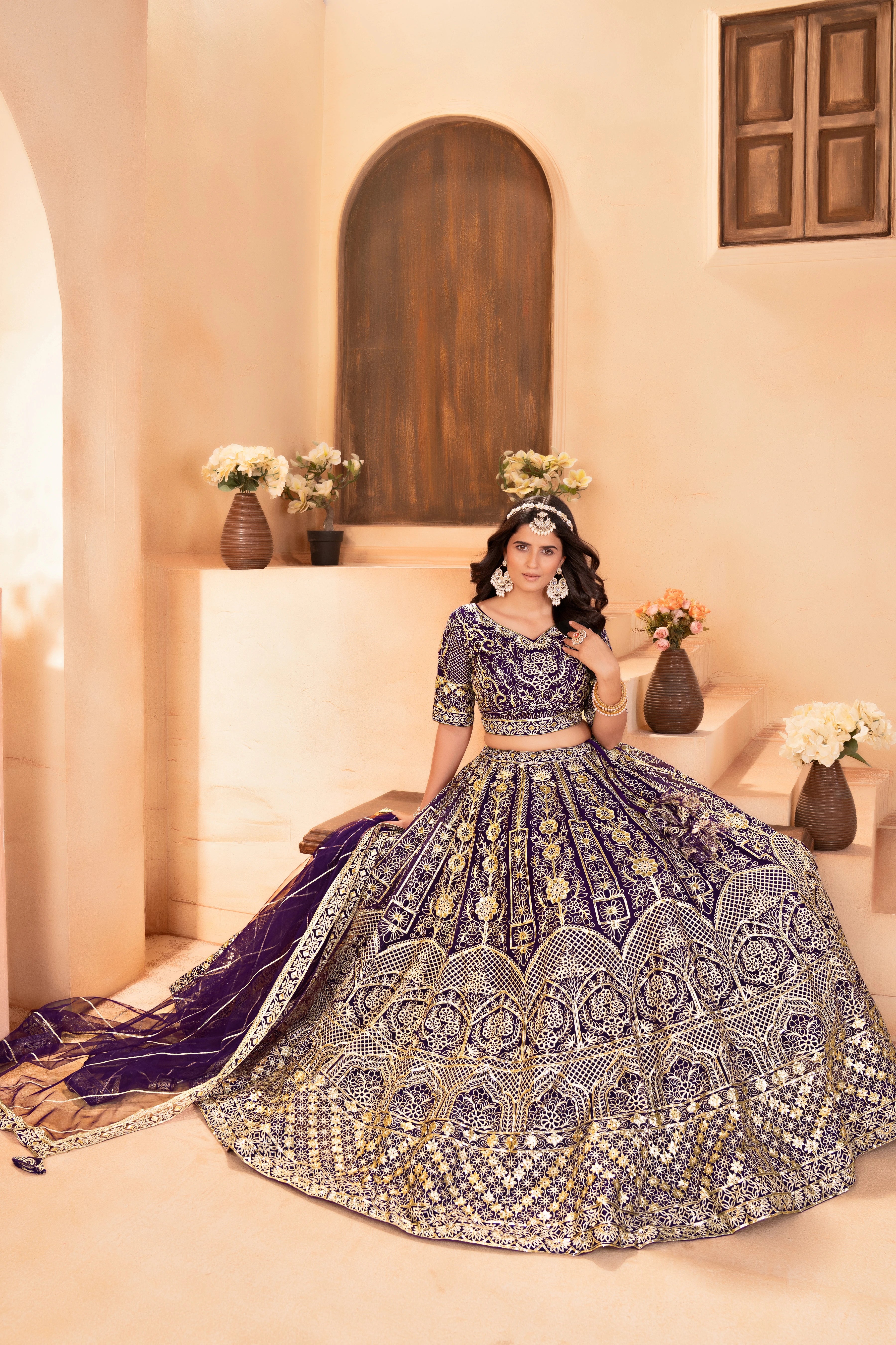 Woman in a traditional embroidered outfit sitting on a couch with decorative elements.