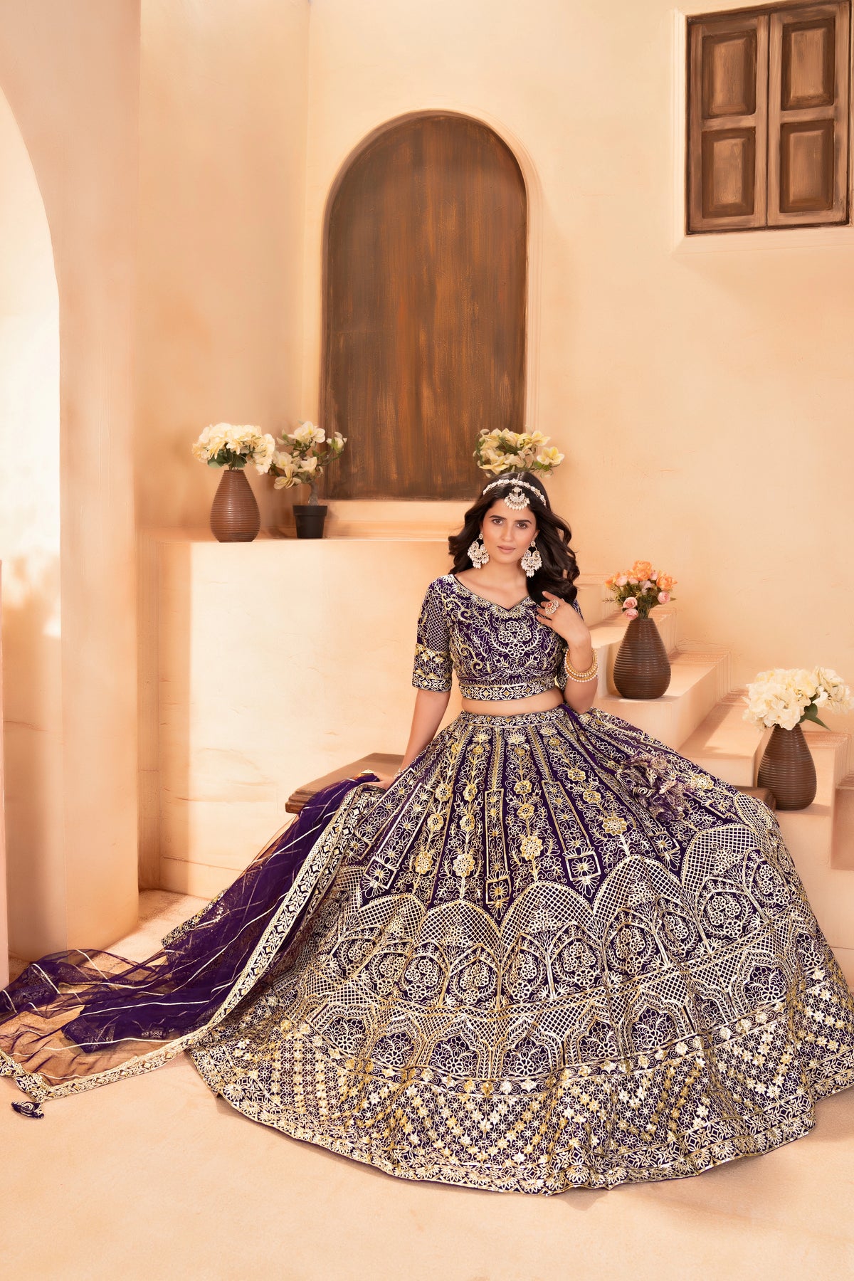 Woman in a traditional embroidered outfit sitting on a couch with decorative elements.