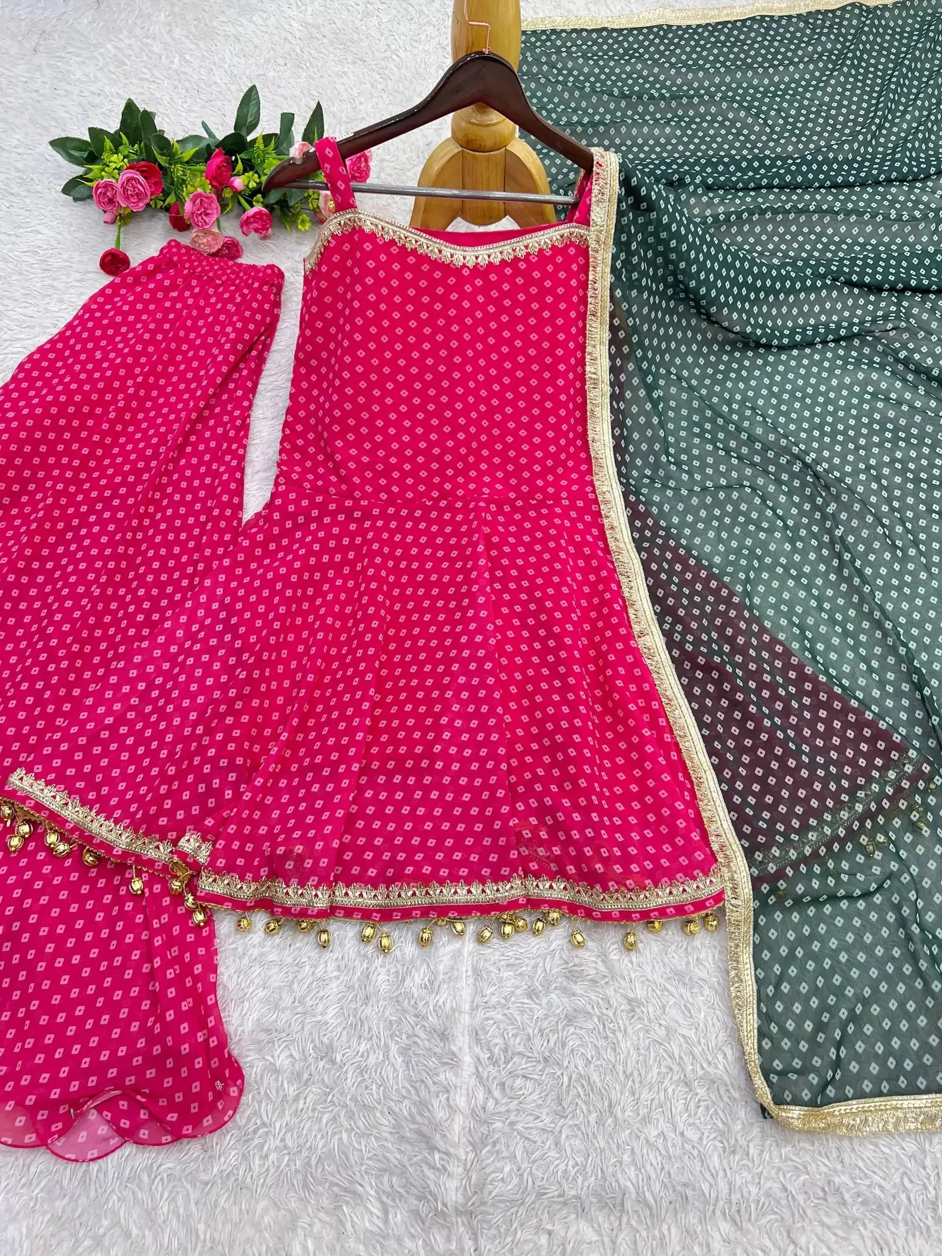 Flat lay of Pink Bandhej Print Suit on hanger with palazzo and green dupatta