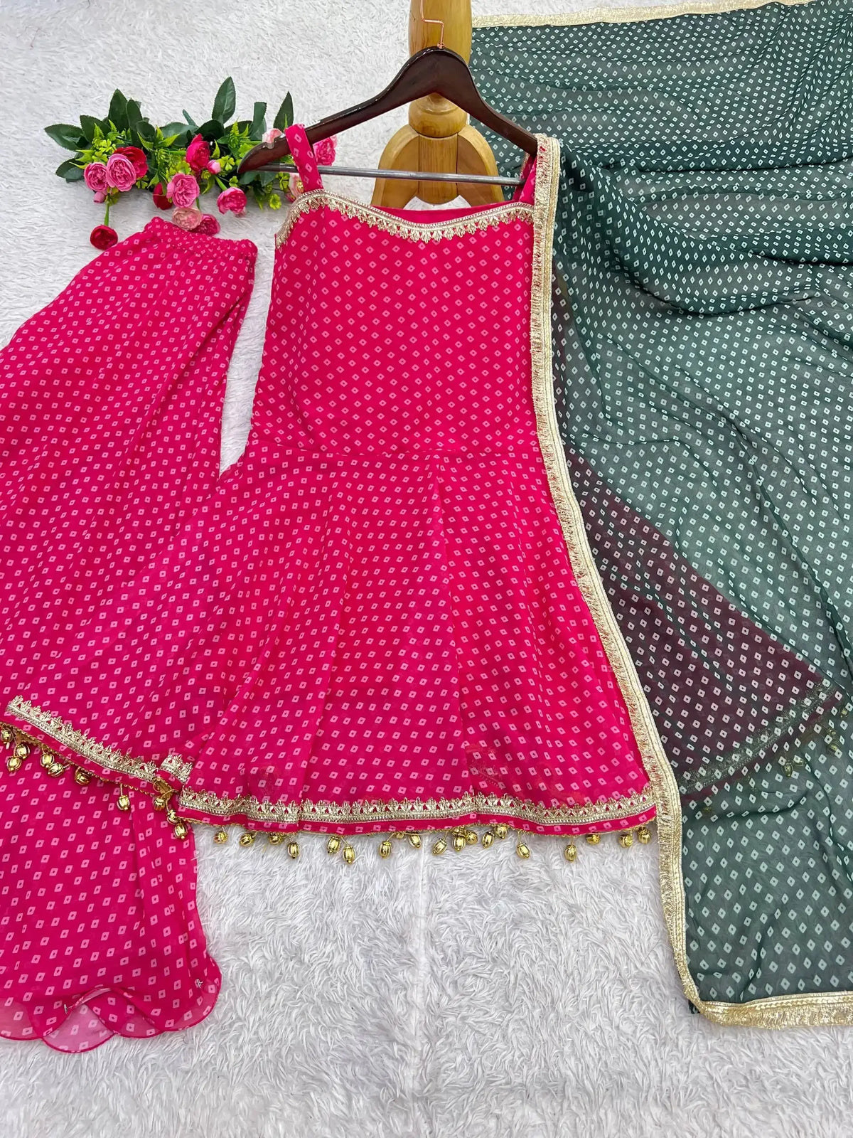 Flat lay of Pink Bandhej Print Suit on hanger with palazzo and green dupatta