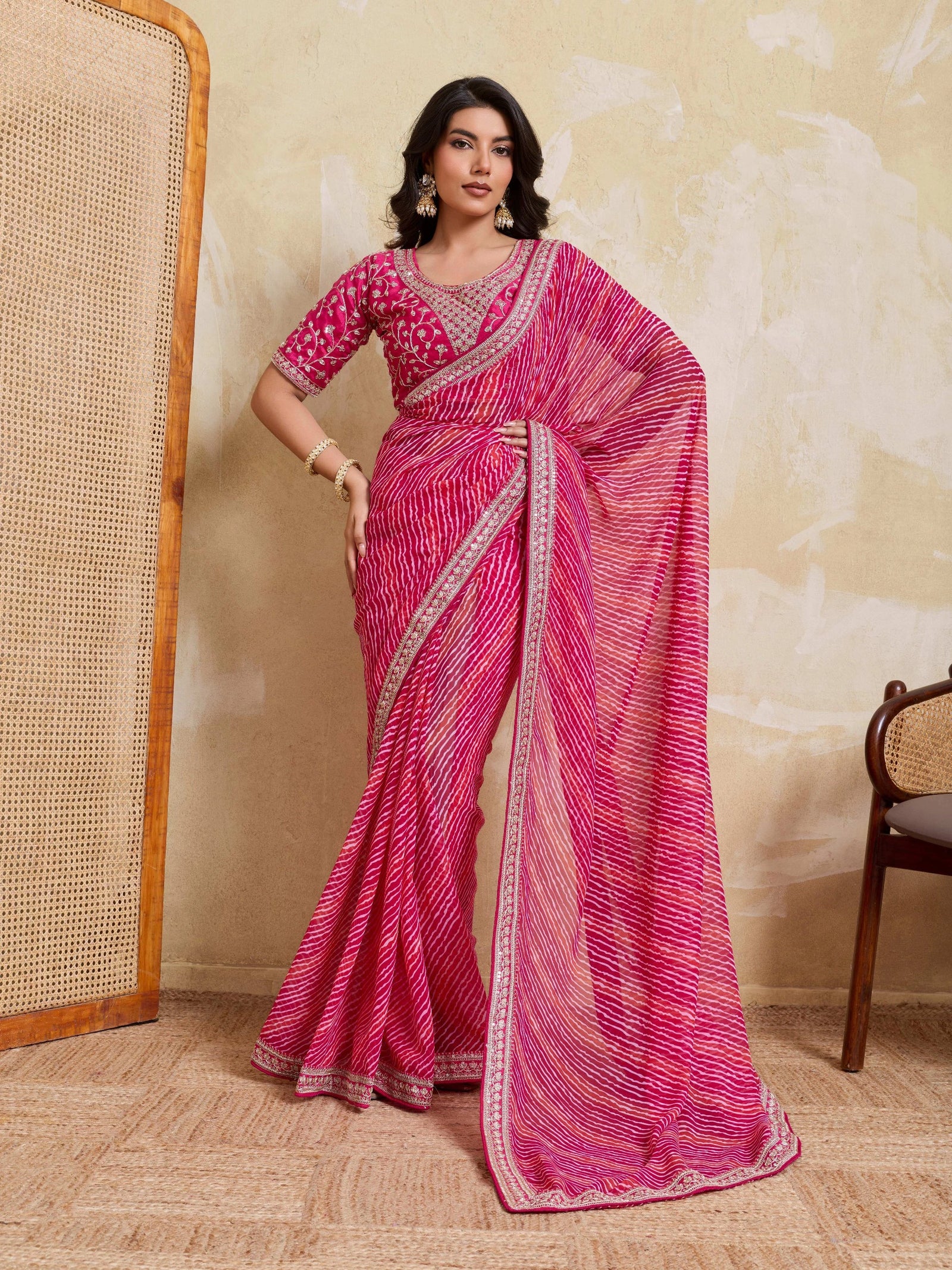 Woman wearing a pink saree with a white background
