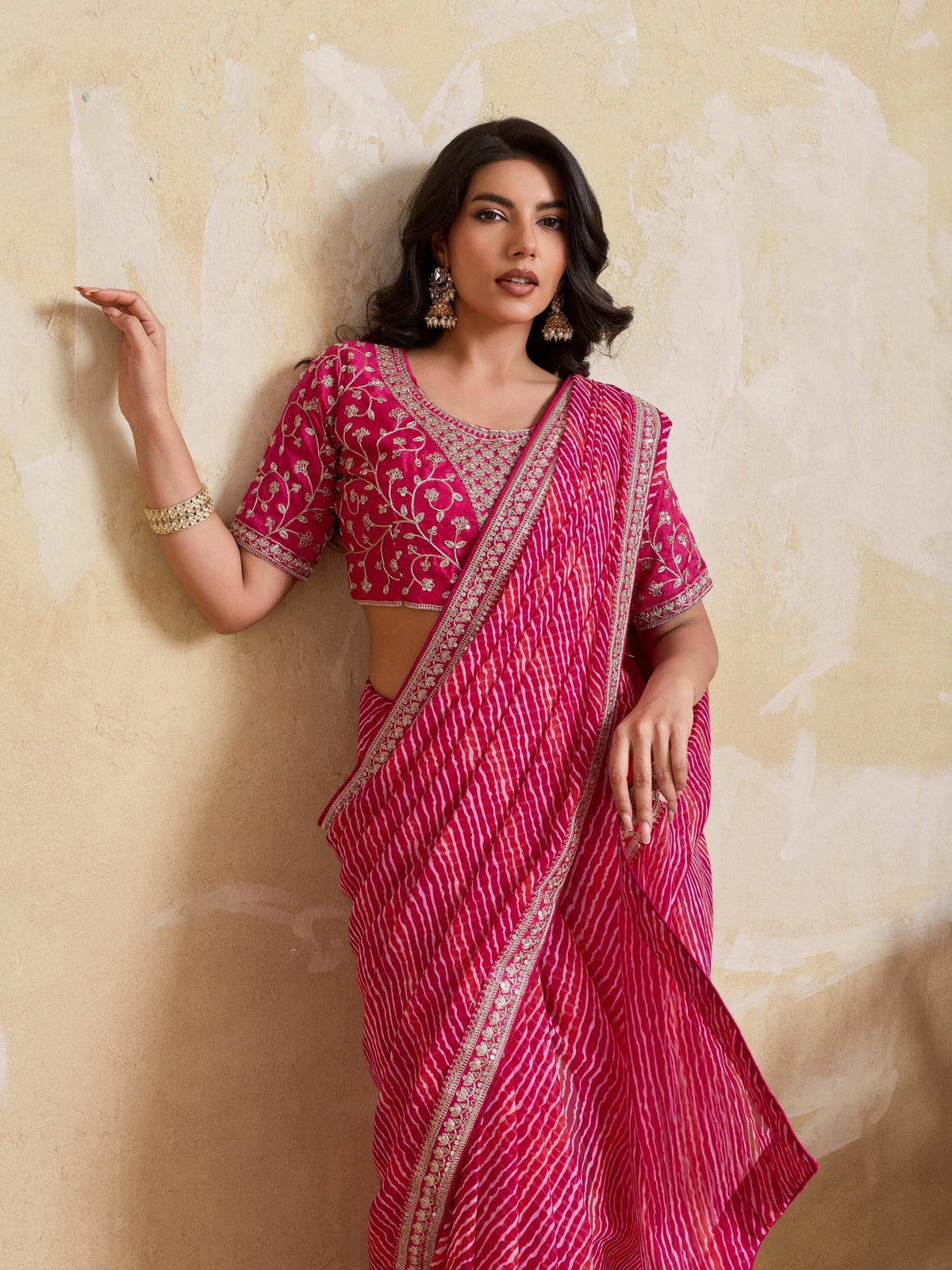 Woman wearing a pink saree with a white background
