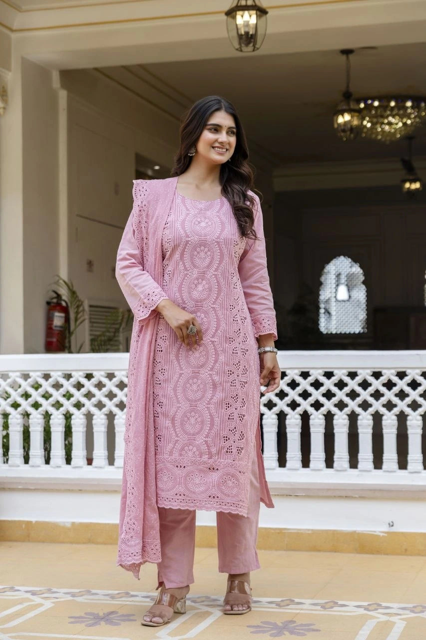 Woman in a pink traditional outfit standing on a balcony.