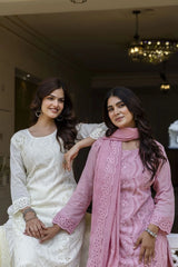 Two women in traditional attire posing together indoors.