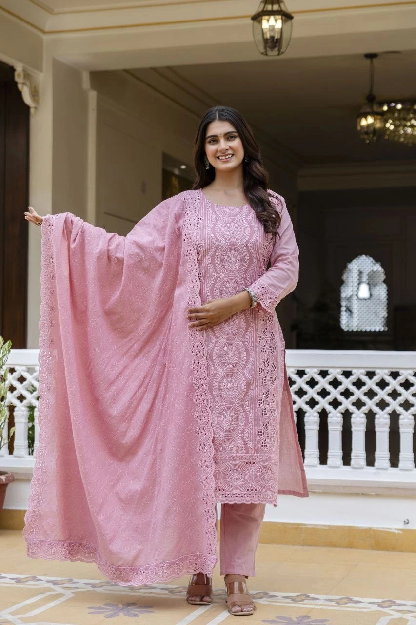 Woman in a pink traditional outfit standing in an indoor setting.