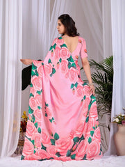 Woman wearing a pink saree with floral patterns against a white curtain background