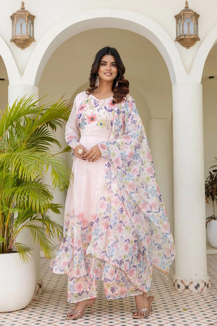 Women's pastel pink floral Anarkali dress featuring delicate flower prints and flowing silhouette.
