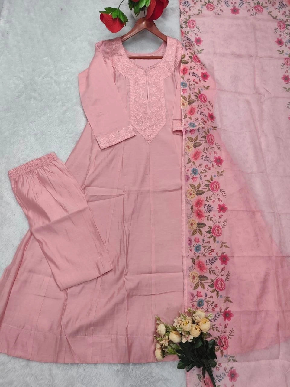 Pink traditional outfit with floral border on a light gray background