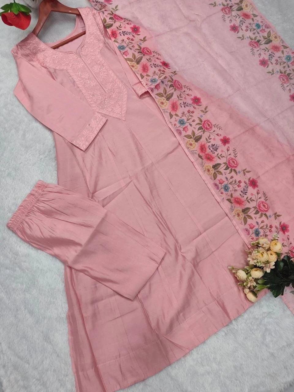 Pink outfit with floral border on a light gray background
