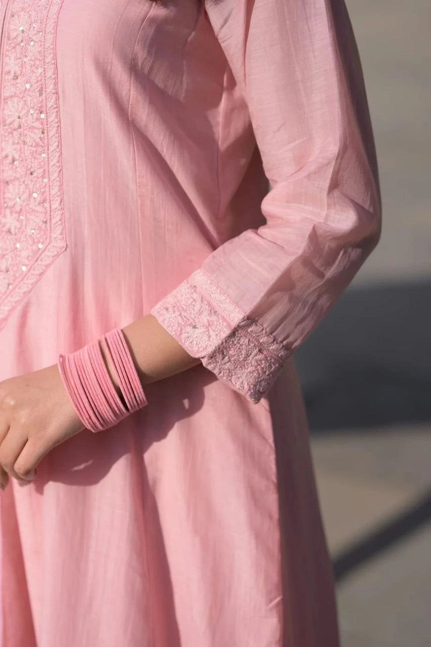 Close-up of a pink traditional outfit with intricate detailing on sleeves and cuffs.