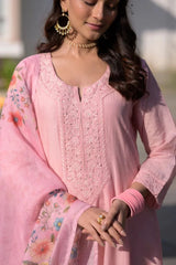 Woman wearing a pink embroidered traditional outfit with floral patterns.