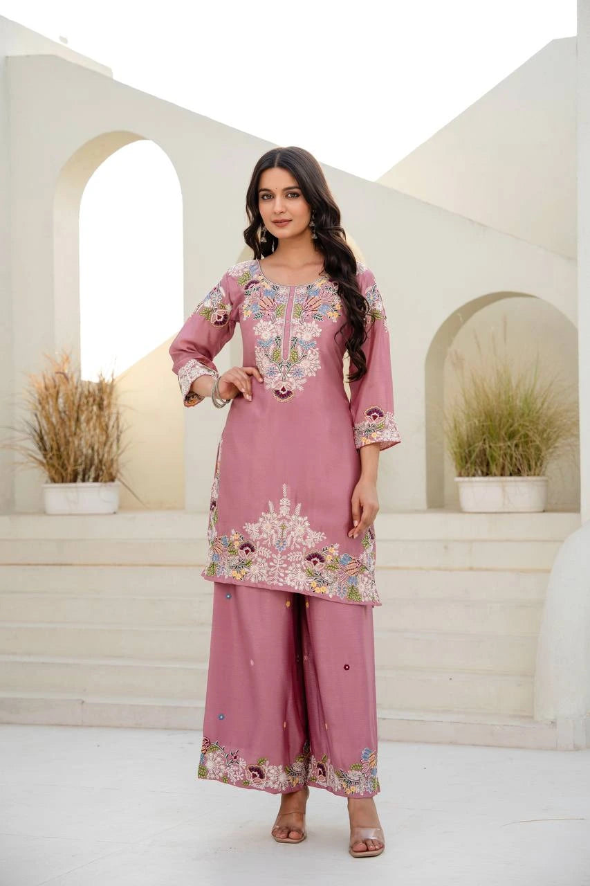 Woman wearing a pink embroidered traditional outfit in a bright setting