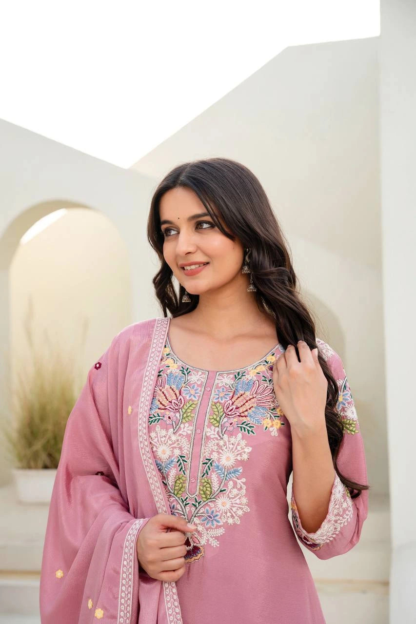 Woman wearing a pink embroidered traditional outfit in an outdoor setting