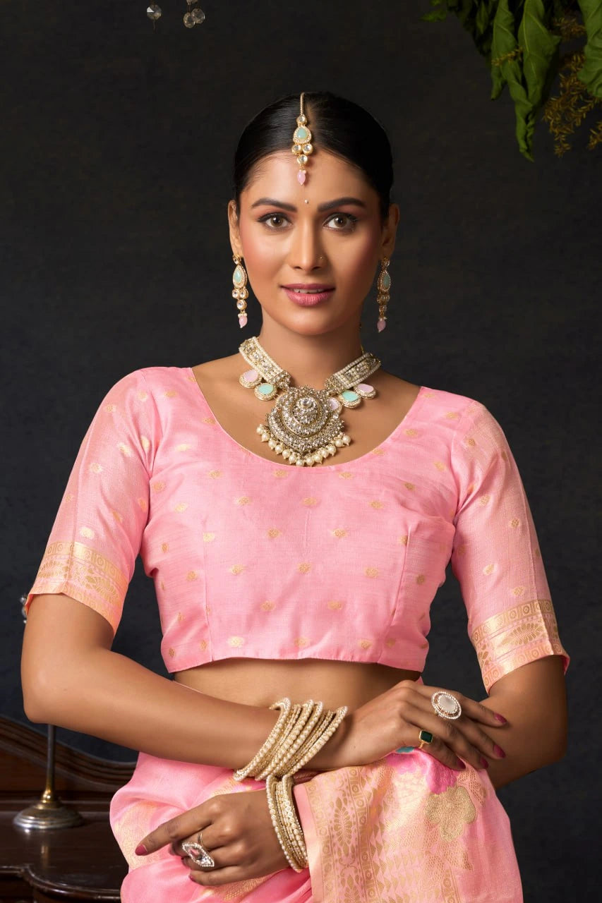 Woman wearing a pink traditional outfit with jewelry against a dark background