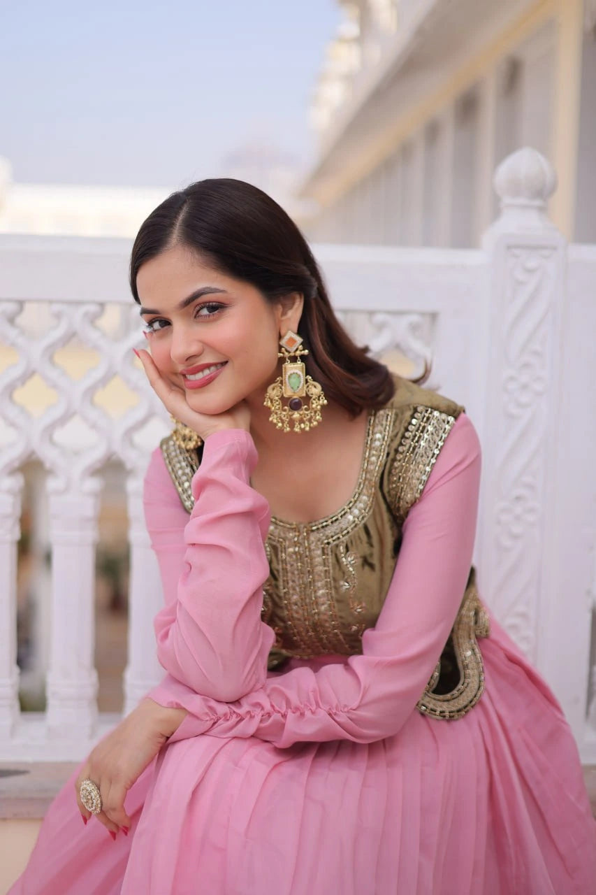 Woman in a pink and gold traditional outfit sitting on a white railing.