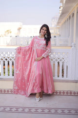 Woman in a pink traditional outfit standing on a balcony