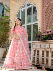 Woman in a pink floral dress standing in front of a decorative building entrance.