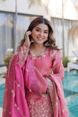 Woman in a pink traditional outfit standing by a pool
