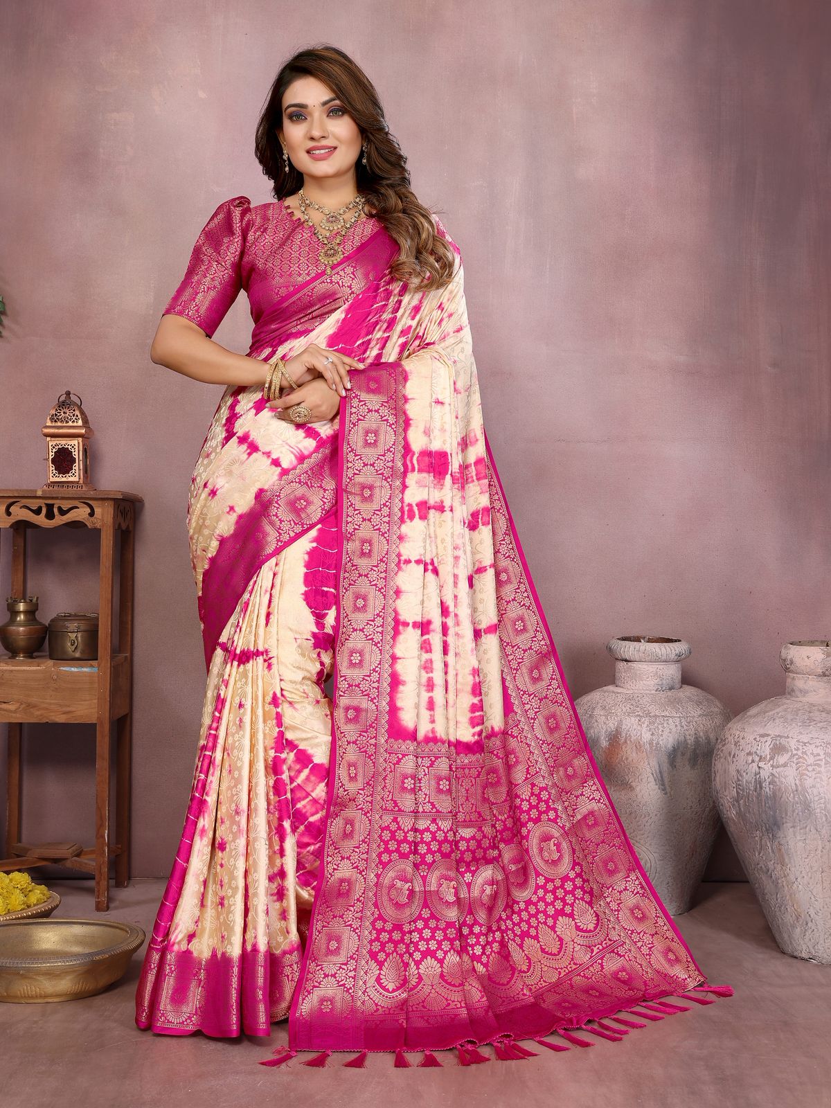 Woman wearing a pink and white saree with a neutral background