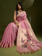 Woman wearing a pink saree with floral embroidery on a green background