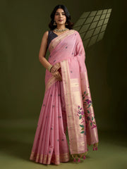 Woman wearing a pink saree with floral patterns on a dark background