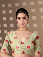 Woman wearing a light green blouse with red floral patterns against a checkered background